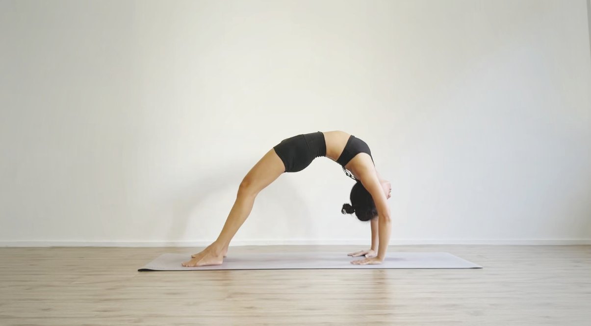 Jiayi guiding a private wheel-pose session in a sunlit Singapore studio